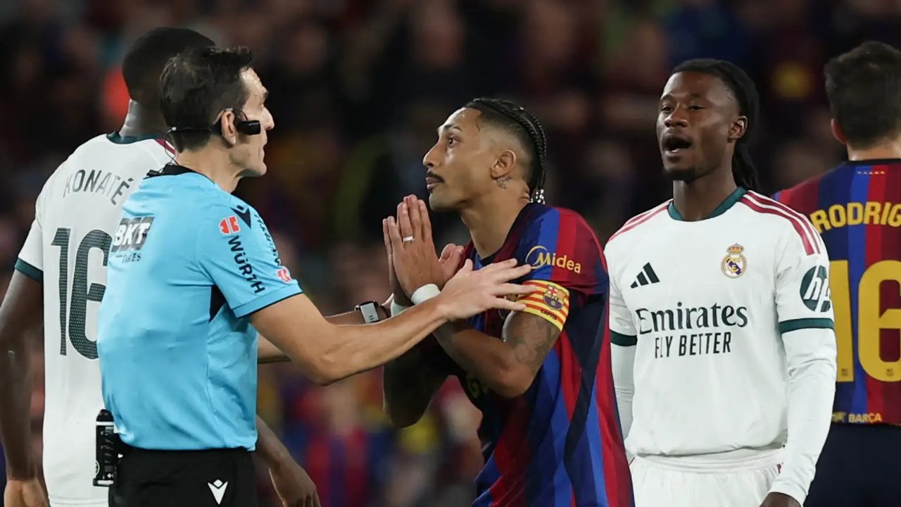 Raphinha pide explicaciones al árbitro durante un partido entre Barcelona y Real Madrid