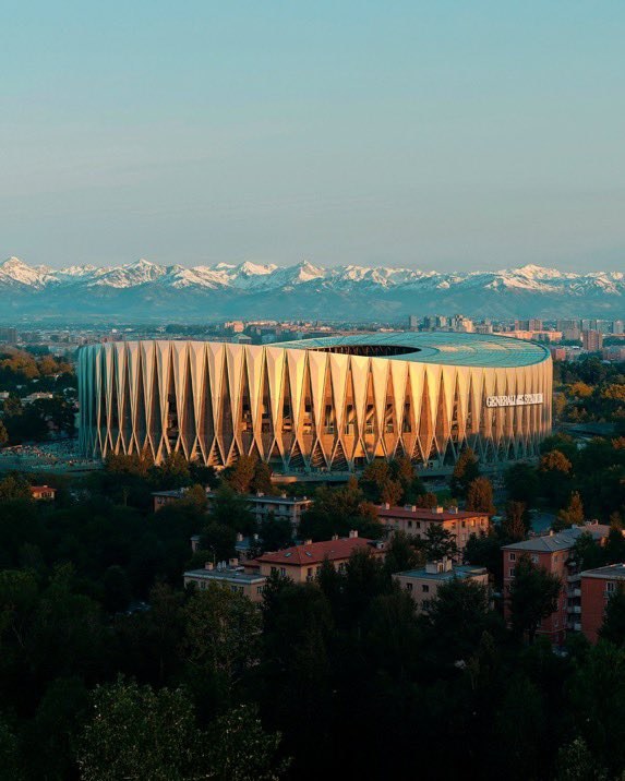 View of the Generali Stadium at sunset with the snow-capped Alps in the background
